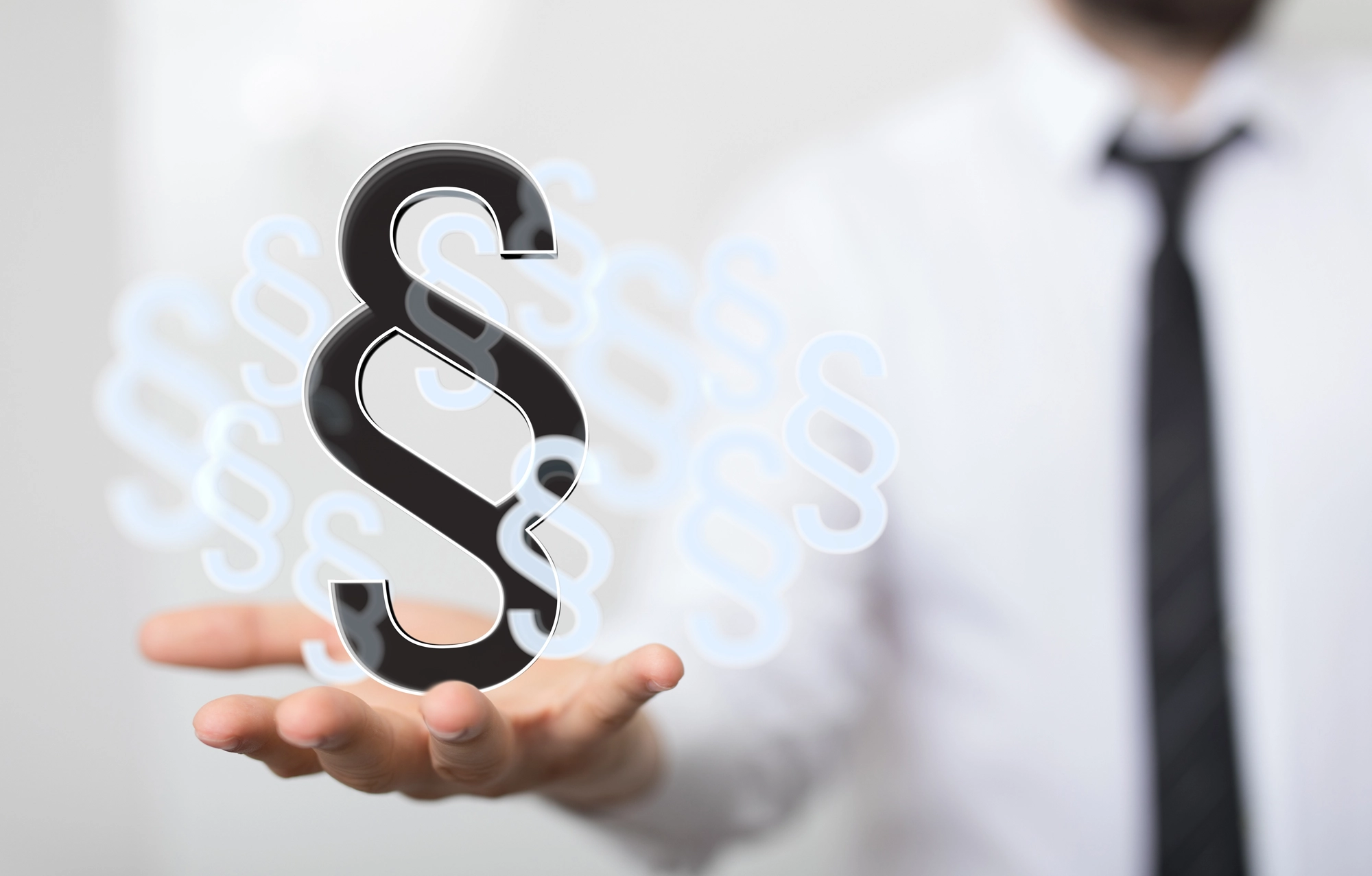 Mann hält Paragrafen-Symbol